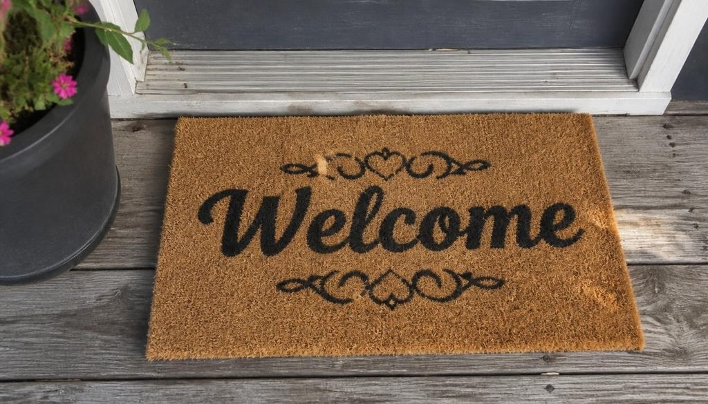Hand-painted coir welcome mat with custom black lettering at front door entrance
